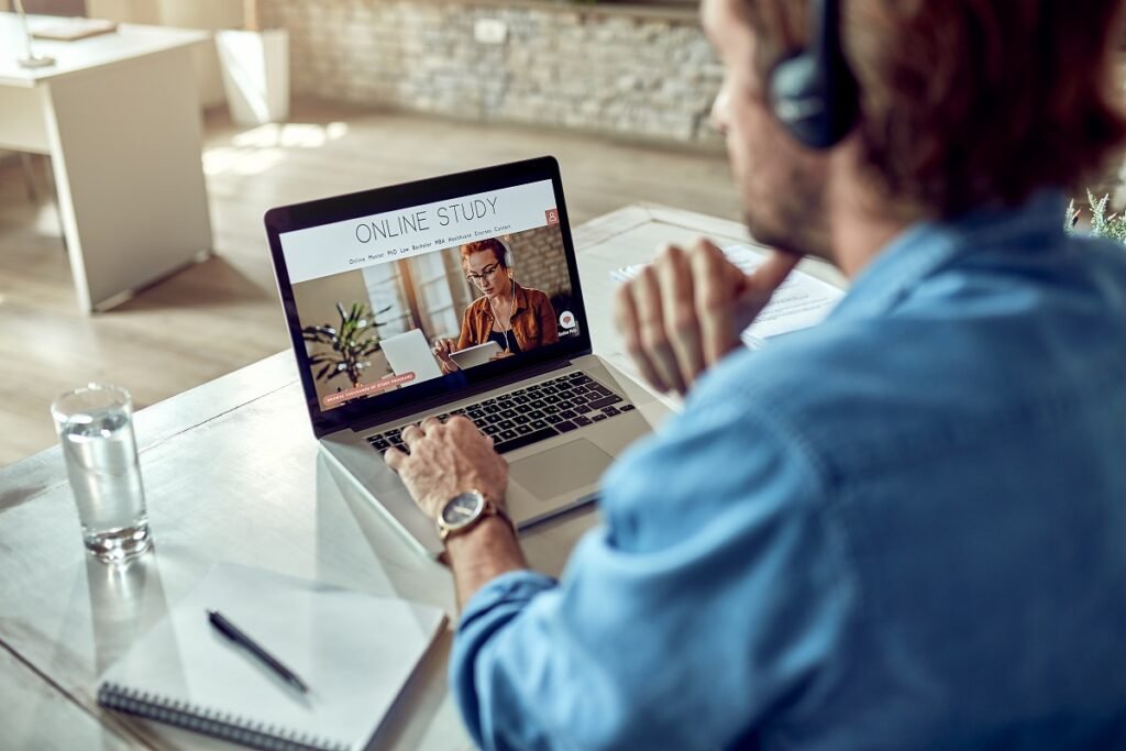 unrecognizable man choosing online study program while using lap