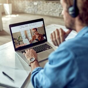 unrecognizable man choosing online study program while using lap